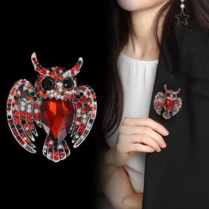 Elegant silver owl brooch with colorful crystals and a large red teardrop gemstone