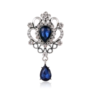 Détails d'une broche baroque vintage argentée avec cristaux bleus en goutte