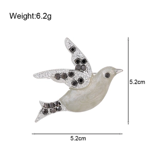 Flying peace dove brooch with white enamel and sparkling rhinestones on silver alloy
