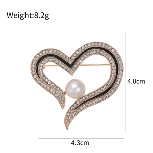 Elegant heart brooch with sparkling crystals and large pearl center on gold base