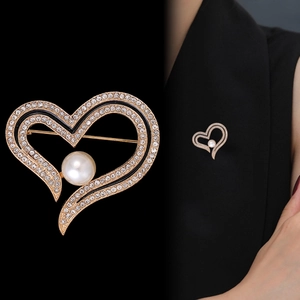 Elegant gold heart brooch with pearls and crystals on a black suit jacket for women