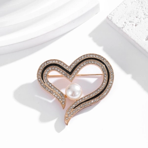 Gold heart brooch with pearls and rhinestones on geometric minimalist white props
