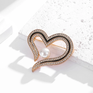 Elegant heart-shaped brooch with pearls and rhinestones on white stone background