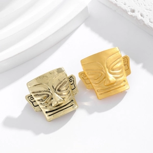 Broches masques Sanxingdui en alliage or et argent sur un socle blanc épuré