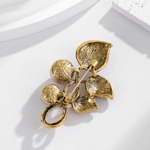 Back view of vintage leaf brooch in antique gold with pearl accents and pin clasp