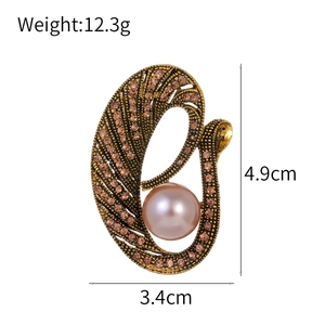 Elegante broche de cisne dorado vintage con cristales rosas y una gran perla central