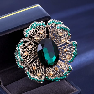 Vintage green crystal flower brooch with emerald stones and hollow filigree design