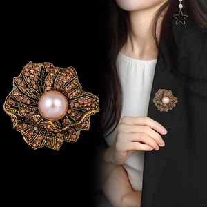 Vintage rose brooch with champagne crystals and pink pearl, shown on black suit jacket