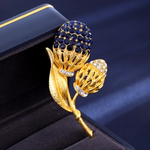 Makroaufnahme der Distelbrosche mit dunkelblauen Kristallknospen und Goldfinish