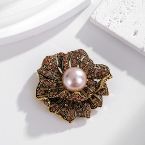 Vintage floral brooch with pink pearl and amber rhinestones on gold-toned metal petals