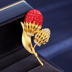 Makroaufnahme der Vintage Haselnuss Brosche mit roten Strasssteinen und Goldlegierung