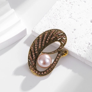 Broche vintage dorado con diamantes de imitación rosas y una gran perla pulida