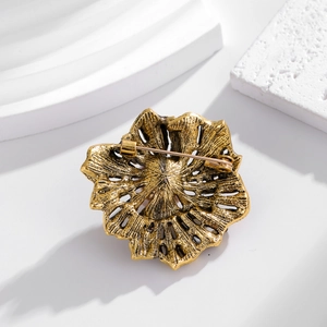 Vintage gold rose flower brooch with rhinestone detail showing back pin closure