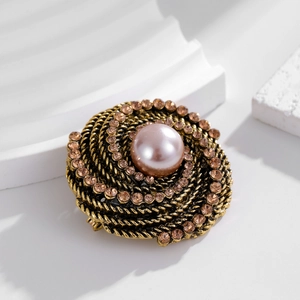 Vintage gold brooch with champagne pearl and rhinestones on a white geometric base