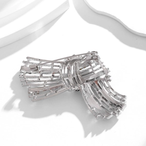 Vintage silver knot brooch with hollow design and diamond accents on a white background