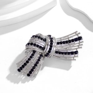 Vintage silver knot brooch with deep blue crystals and fine bead edge for suits