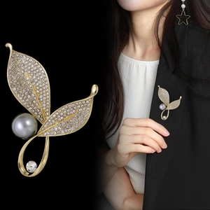 Elegant gold leaf brooch with gray pearl and crystals shown on black blazer for women