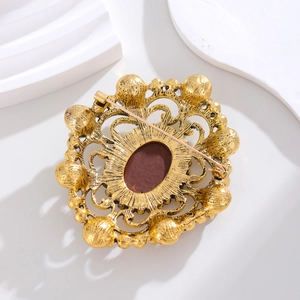 Vintage hollowed-out gold brooch with brown gemstone and back pin detail
