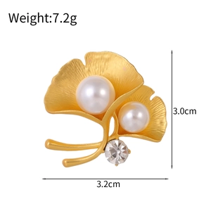 Elegant gold ginkgo leaf brooch featuring two white pearls and a sparkling rhinestone