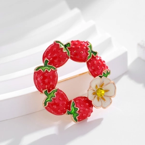 Floral strawberry wreath brooch in red enamel and gold finish on white display