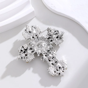 Back view of silver vintage cross brooch showing safety pin clasp and textured finish