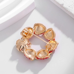 Back view of red enamel flower brooch with gold plated metal base and secure pin clasp
