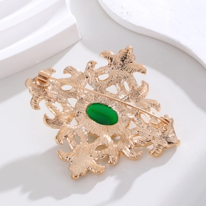 Spilla barocca vintage con gemma verde e motivo floreale traforato dorato, gioiello elegante