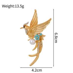 Vintage style gold hummingbird brooch with white pearl and blue floral accents