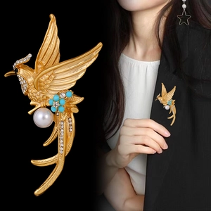 Vintage kingfisher brooch with large pearl and blue enamel flowers on black background
