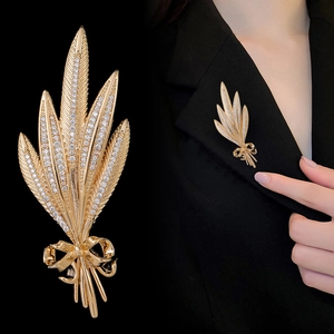Elegant gold wheat ear brooch with zircons and bow, featuring close-up and model view
