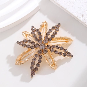 Exquisite golden floral brooch with dark grey rhinestones and woven metal petals
