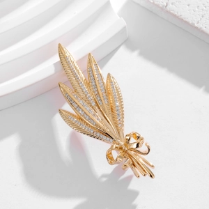 Macro shot of gold wheat brooch with ribbon bow and sparkling cubic zirconia stones