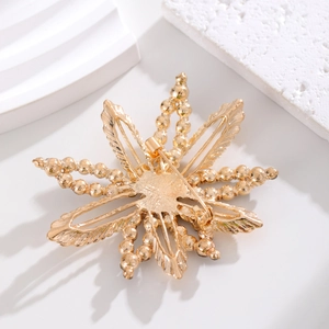Back view of gold maple leaf brooch showing secure pin clasp and electroplated finish