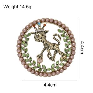 Broche lion vintage dorée avec couronne et perles roses sur fond blanc pur