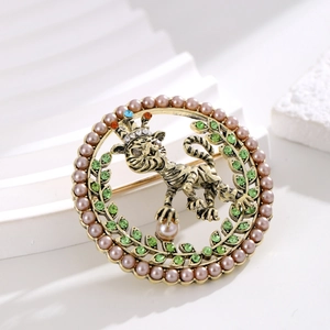 Broche lion vintage dorée avec perles violettes et cristaux verts sur socle blanc