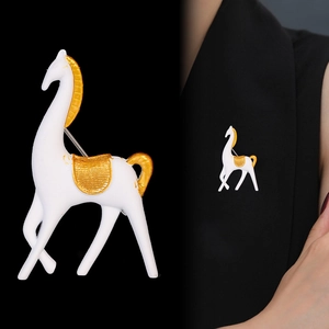 Broche cheval blanche mate élégante avec détails dorés, vue produit et portée sur mannequin
