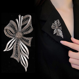 Vintage style bow brooch with brown rhinestones and antique silver finish shown on suit