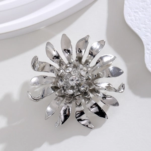 Broche fleur argentée avec cristaux sur socle en pierre au style minimaliste chic