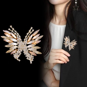 Elegant gold butterfly brooch with champagne crystals pinned on a black suit jacket