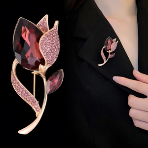 Macro detail and model view of luxury glass tulip brooch with burgundy gems on black suit