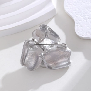 Back view of silver camellia pearl brooch with matte brushed texture and pin closure