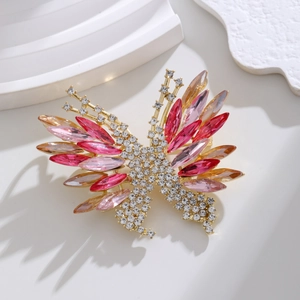 Elegant gold butterfly brooch with pink and amber crystals on white display stand