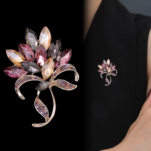 Elegant floral crystal brooch with pink and champagne stones on a black suit blazer