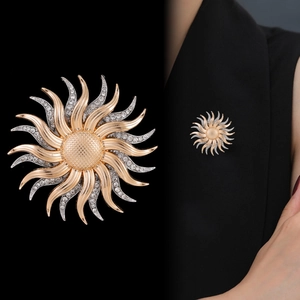 Elegant 18K gold sunburst brooch with silver accents and sparkling white rhinestones