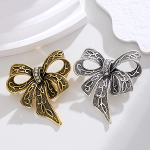 Vintage bow brooches in antique gold and silver with embossed patterns and crystals