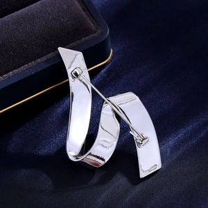 Back view of silver spiral ribbon brooch with polished finish and secure pin fastener