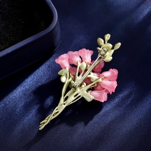 Spilla bouquet di rose elegante con boccioli rosa e foglie dorate su seta blu