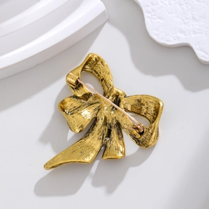 Vintage gold alloy bow brooch pin back view showing locking mechanism on stone