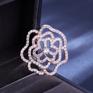 Exquise broche fleur en or rose sertie de zircons blancs sur une boîte à bijoux
