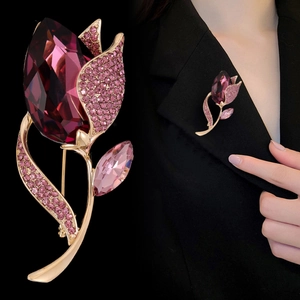 Détail de broche tulipe avec cristal violet et pierres roses sur revers de veste noir
